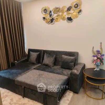 Cozy living room with plush gray sofa, elegant wall art, and stylish side tables.