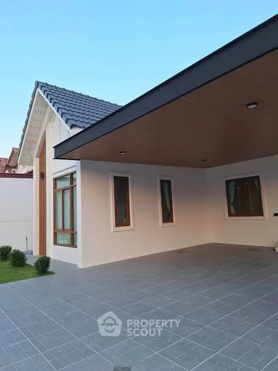 Modern single-story house with spacious carport and elegant roof design.