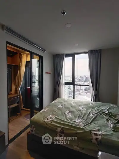 Cozy bedroom with city view and adjacent study area in modern apartment