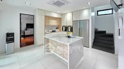 Modern kitchen with island, sleek cabinetry, and stainless steel appliances in a contemporary home.