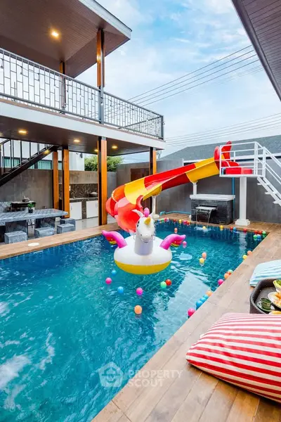 Luxurious modern home with vibrant pool and slide, perfect for family fun and relaxation.