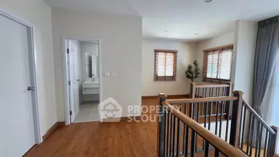 Spacious upper floor hallway with wooden flooring and natural light
