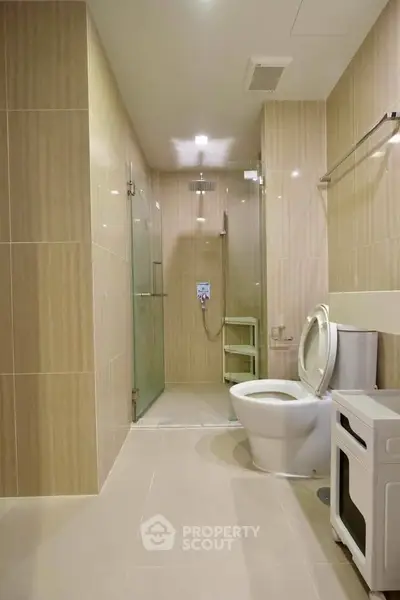 Modern bathroom with glass shower and sleek fixtures in a contemporary apartment.