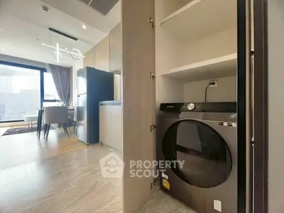 Modern apartment interior with open kitchen and built-in laundry area