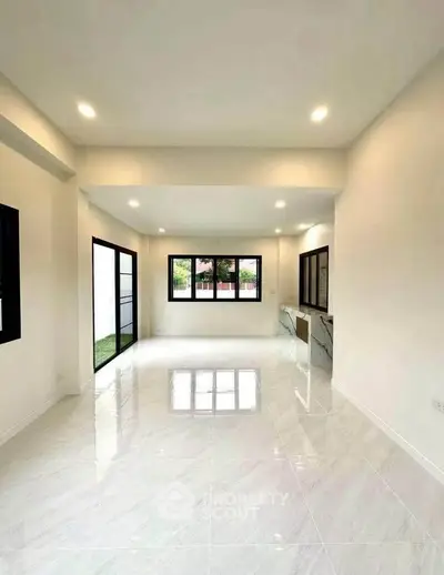 Spacious modern living room with large windows and glossy tile flooring