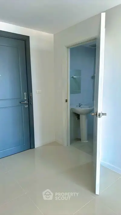 Modern apartment entrance with sleek bathroom access and elegant door design.