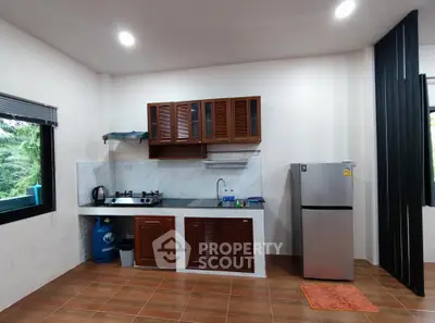 Modern kitchen with wooden cabinets and stainless steel fridge in cozy apartment