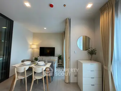 Modern and inviting open-plan living space with a cozy dining area, sleek furnishings, and abundant natural light, perfect for urban living.