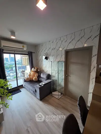 Modern living room with city view, stylish decor, and cozy seating area in a high-rise apartment.
