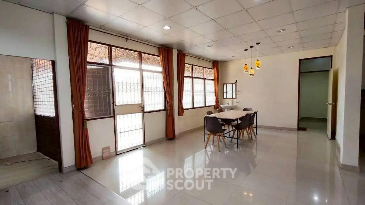 Spacious dining area with modern lighting and large windows for natural light.