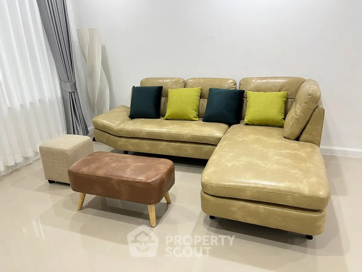 Modern living room with stylish beige leather sofa and colorful cushions