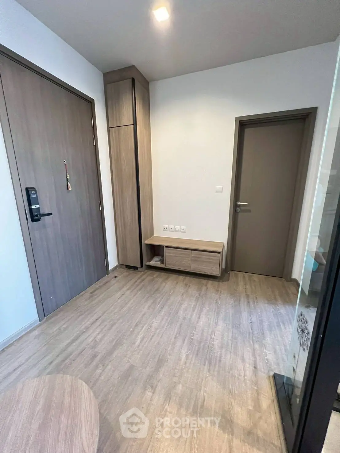 Modern apartment entrance with sleek wooden flooring and minimalist design