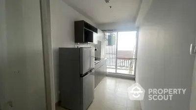 Modern compact kitchen with natural light and sleek appliances