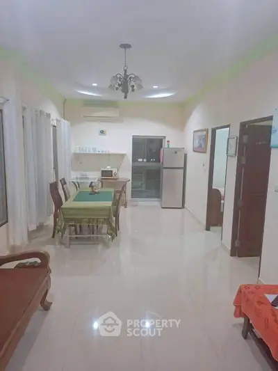 Spacious dining area with elegant furniture and modern appliances in a well-lit room.