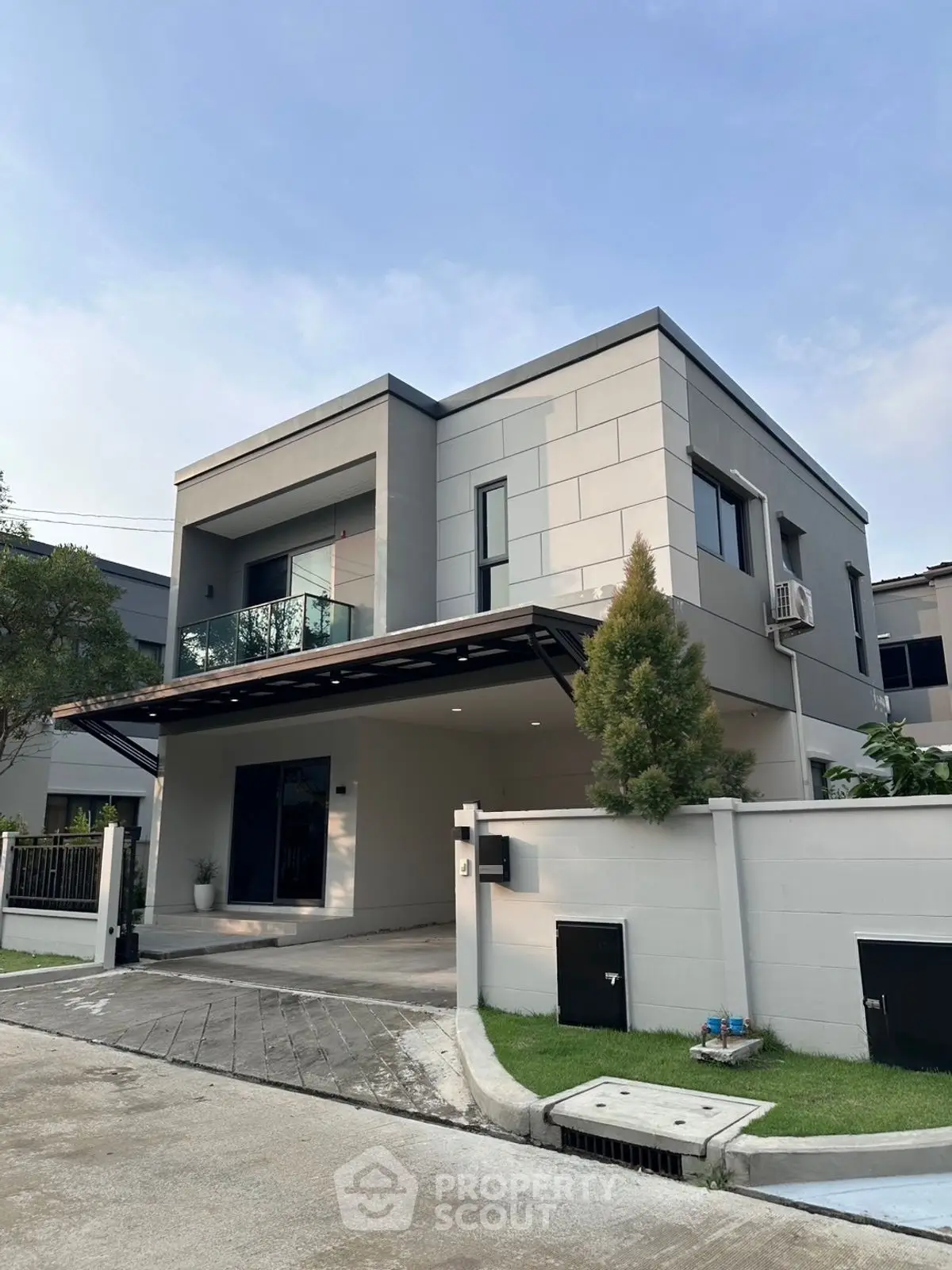 Modern two-story house with sleek design and balcony in a serene neighborhood.