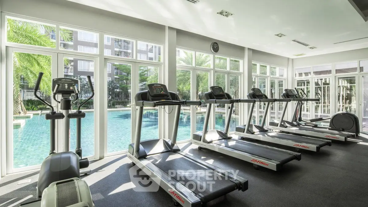Modern gym with pool view in luxury residential complex