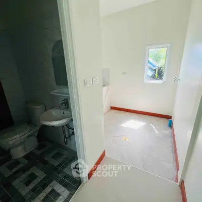 Bright bathroom with modern fixtures and natural light, featuring a sleek design and tiled flooring.
