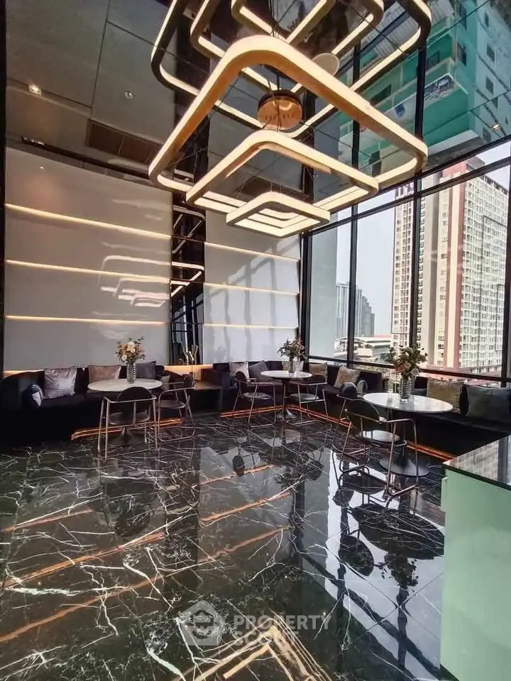 Luxurious modern lobby with marble floors and stylish lighting in high-rise building.