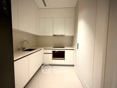 Modern minimalist kitchen with sleek white cabinetry and built-in appliances