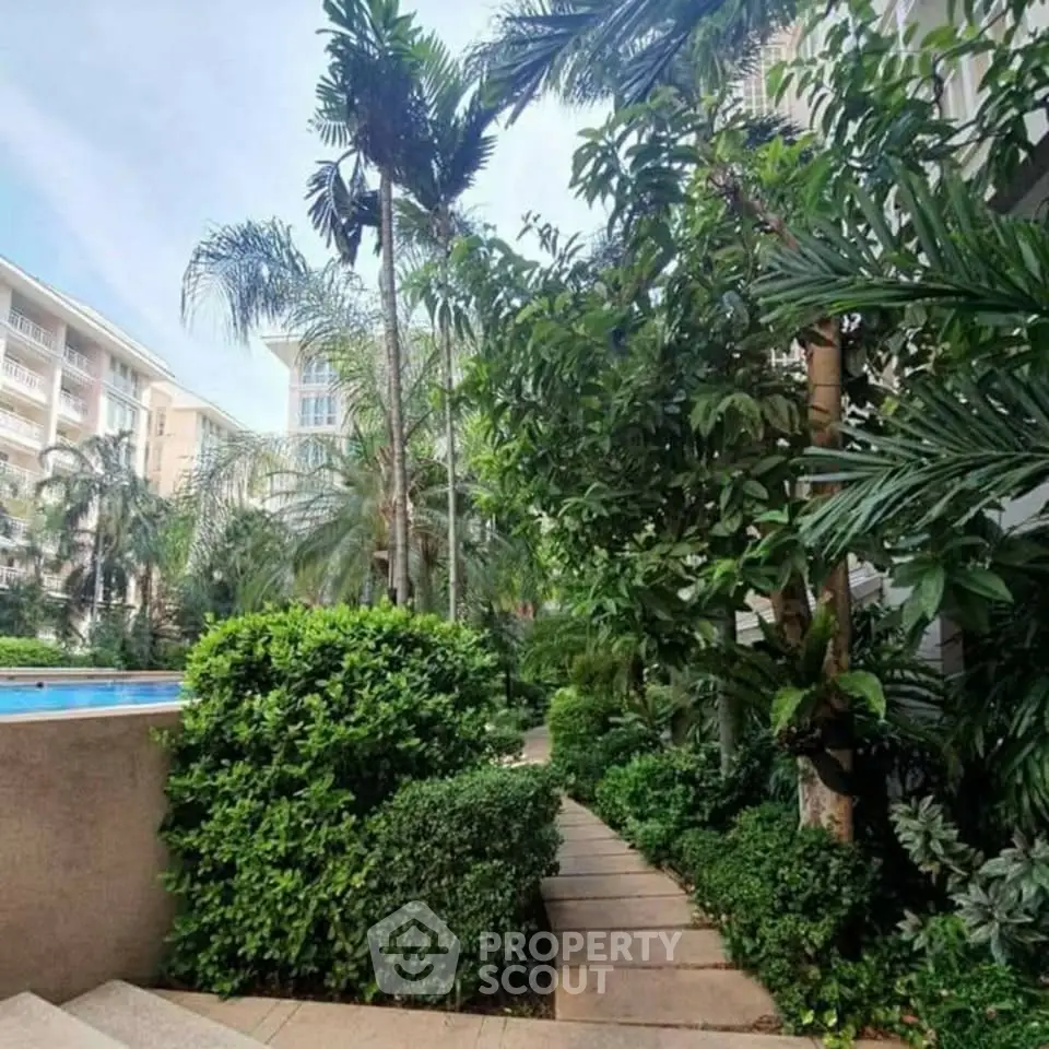 Lush garden pathway with tropical plants in a modern residential complex