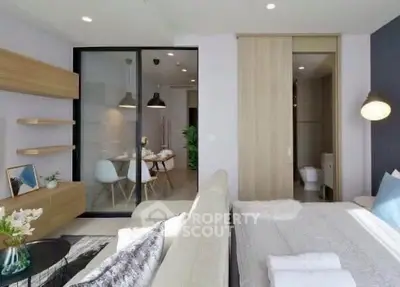 Modern open-plan living room with dining area, featuring sleek furniture and natural light.