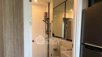 Modern bathroom with sleek shower and mirrored walls in contemporary apartment.