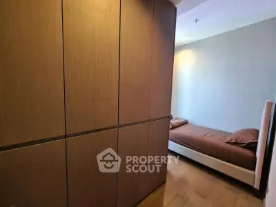 Cozy bedroom with wooden wardrobe and single bed, perfect for minimalist living.