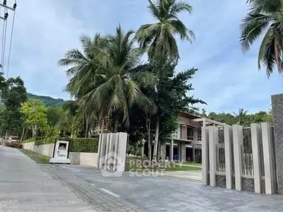 Tropical modern villa with palm trees and gated entrance
