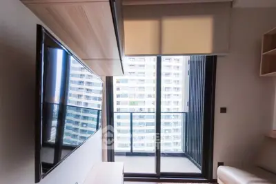 Modern apartment living room with large TV and balcony view