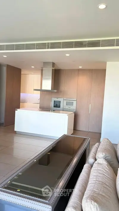 Modern open-layout kitchen with sleek appliances and stylish cabinetry in a luxurious apartment.