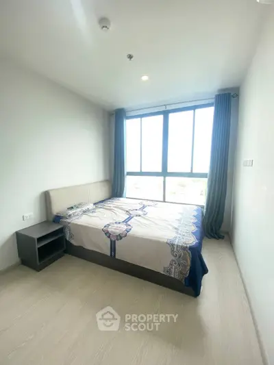 Bright bedroom with large window and modern decor in a stylish apartment.