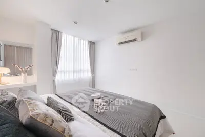 Modern bedroom with elegant decor and natural light, featuring a cozy bed and stylish furnishings.