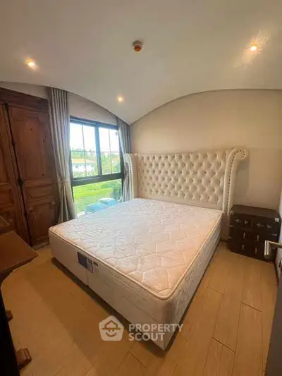 Cozy bedroom with elegant tufted headboard and large window view