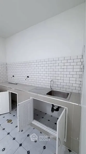 Modern kitchen with white subway tiles and open cabinets, perfect for customization.