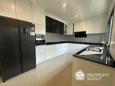 Modern kitchen with sleek black and white cabinetry and spacious layout