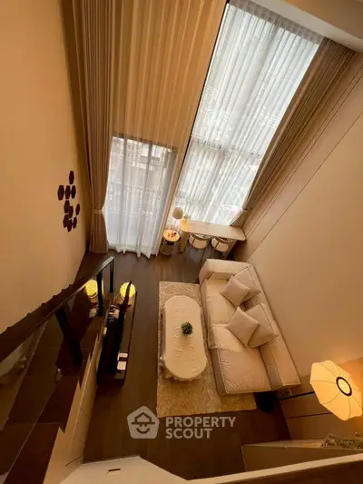 Luxurious high-ceiling living room with elegant decor and large windows for natural light.