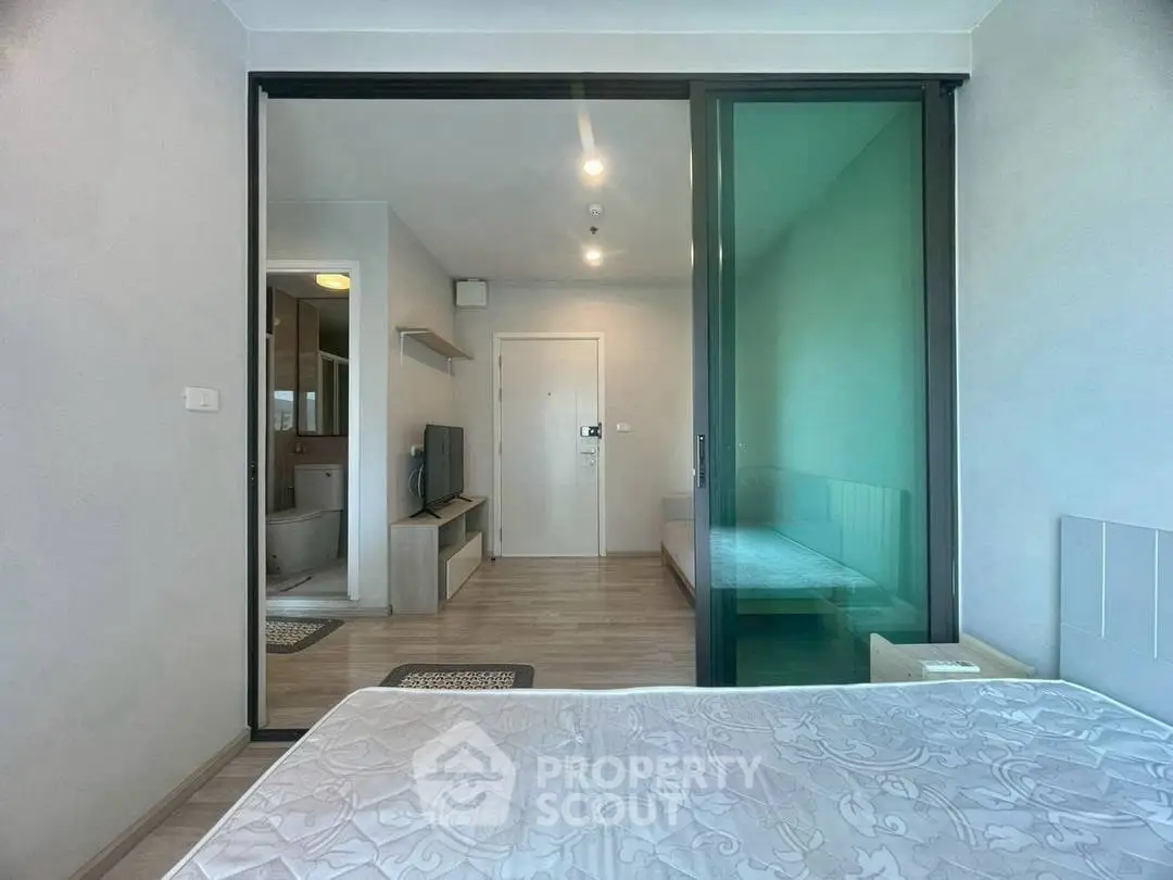 Modern bedroom with sliding glass door and view into living area