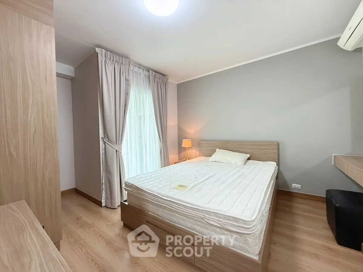 Cozy bedroom with wooden flooring and natural light