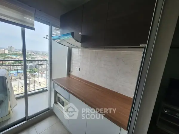 Modern kitchen with sleek cabinetry and balcony view, perfect for urban living.