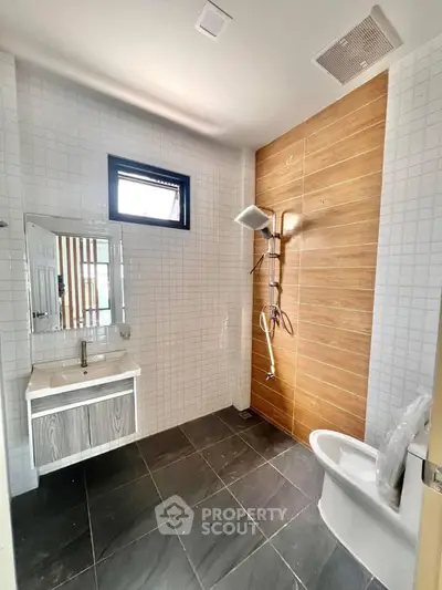 Modern bathroom with sleek fixtures and stylish tile design, featuring a spacious shower area and contemporary vanity.