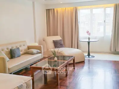 Spacious living room with elegant furniture and large window for natural light.