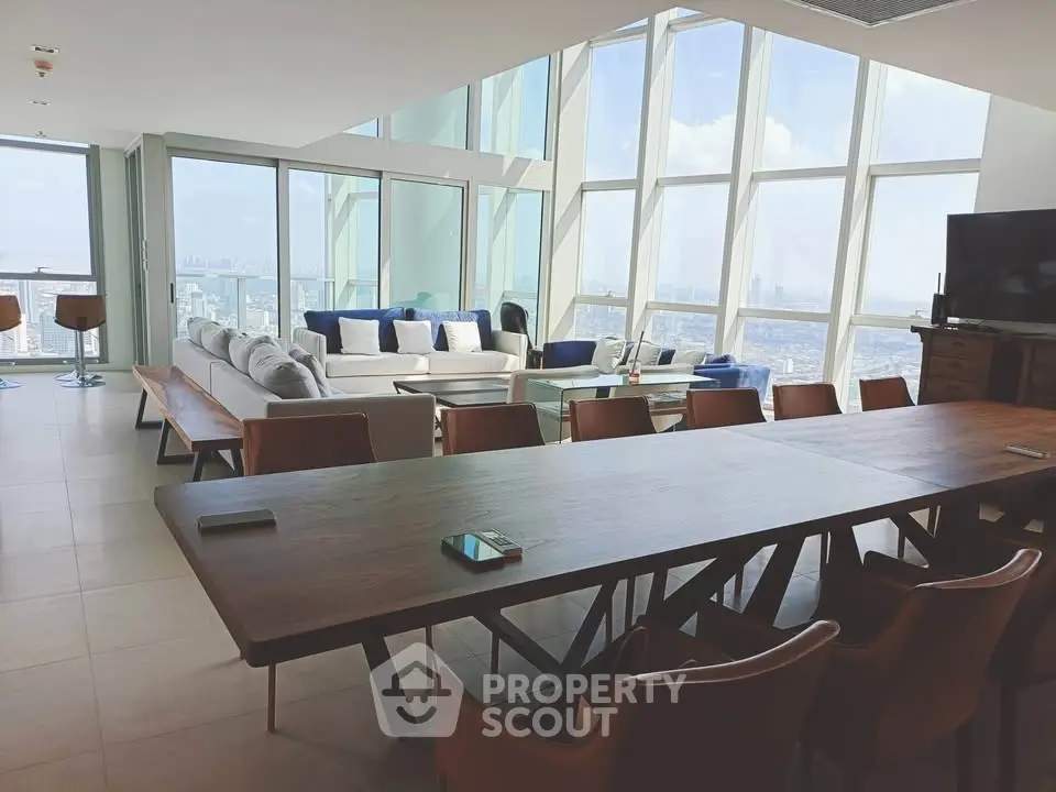 Luxurious penthouse living room with panoramic city views and modern furnishings.