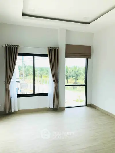 Bright and spacious room with large windows and scenic view, perfect for modern living.
