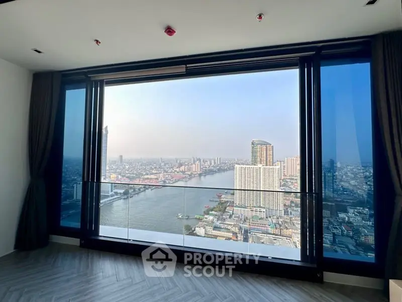 Luxurious high-rise corner unit with floor-to-ceiling windows offering panoramic city and river views, modern design, and ample natural light.
