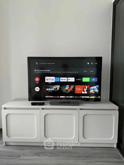 Modern living room with sleek TV stand and flat-screen TV displaying streaming apps.