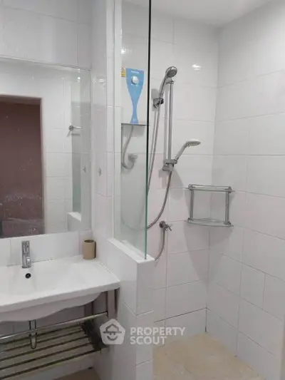 Modern bathroom with sleek shower and white tiles, perfect for a contemporary home.