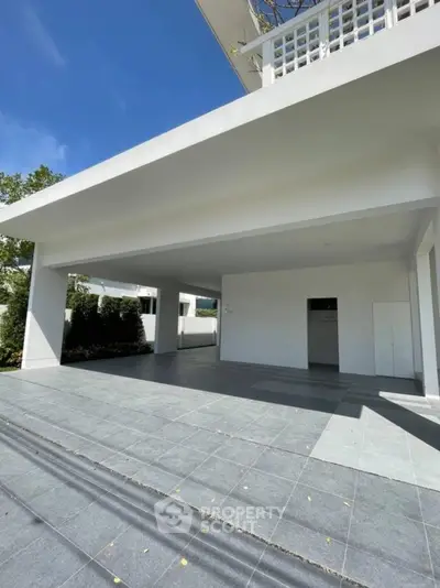Modern minimalist building exterior with spacious covered parking area