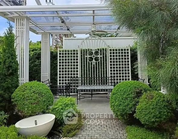 Charming garden with elegant pergola and lush greenery, perfect for outdoor relaxation.