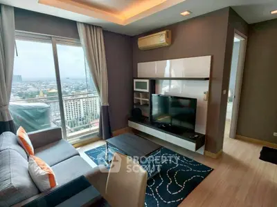 Modern living room with city view, featuring stylish furniture and entertainment center.