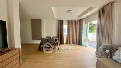 Spacious living room with modern dining area and large windows